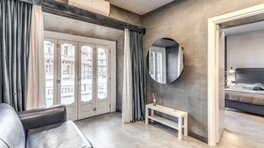 A modern hotel room with a large window, a round mirror, a bed, and a seating area with a bench. - Lady Diamond (Naples)