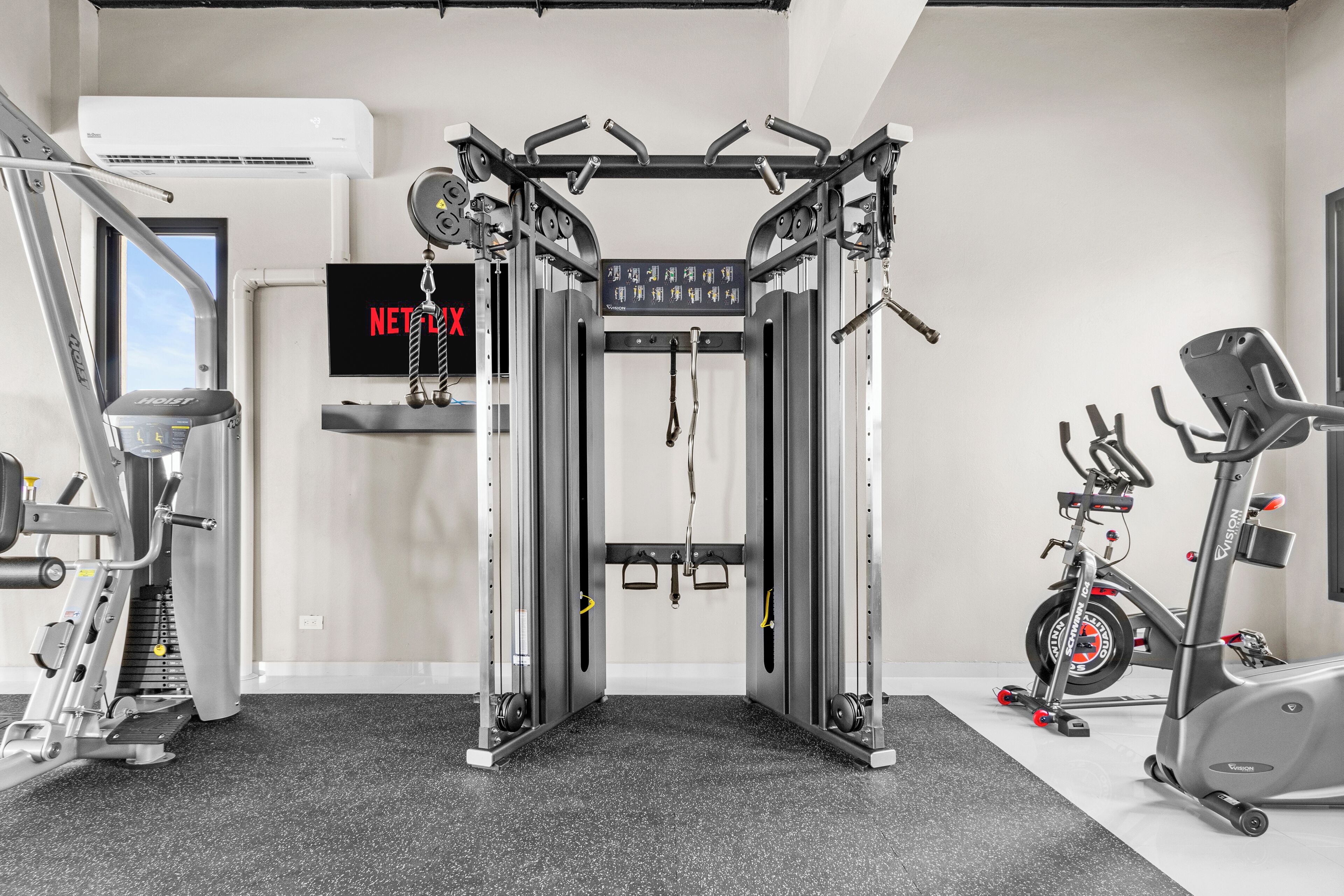 Una palestra con una sbarra per trazioni, macchinari per pesi e una cyclette.