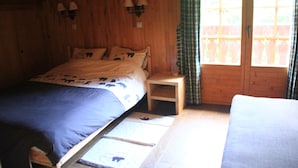 A bedroom with a bed, bedside tables, and a window with curtains. - Apartment With Parking in Chatel (Chatel)