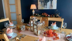 A dining table set with white plates, pink napkins, and clear wine glasses. - Overlooking Carlingford Lough Modern and Spacious! (Warrenpoint)