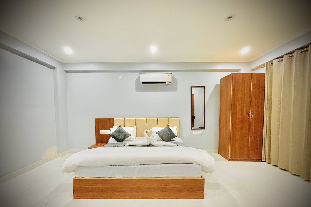 Un dormitorio moderno con una cama grande, un armario y un equipo de aire acondicionado.