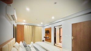 A modern bedroom with a bed, curtains, a television, and a wardrobe. - Hotel Grand Aana Inn (Jaipur)