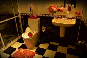 Et badeværelse med toilet, vask og et skakternet gulv.