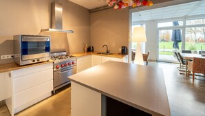 Una cocina moderna con horno empotrado, estufa y una isla grande.