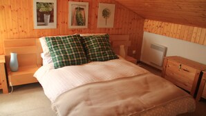 A wooden-paneled bedroom with a bed, a nightstand, a dresser, and a radiator. - Myrtilles Mr27 Telecabine & Nature 6 Pers (Chatel)