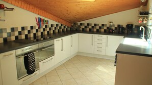 A kitchen with a sloped ceiling, a built-in oven, and a checkered backsplash. - Myrtilles Mr27 Telecabine & Nature 6 Pers (Chatel)
