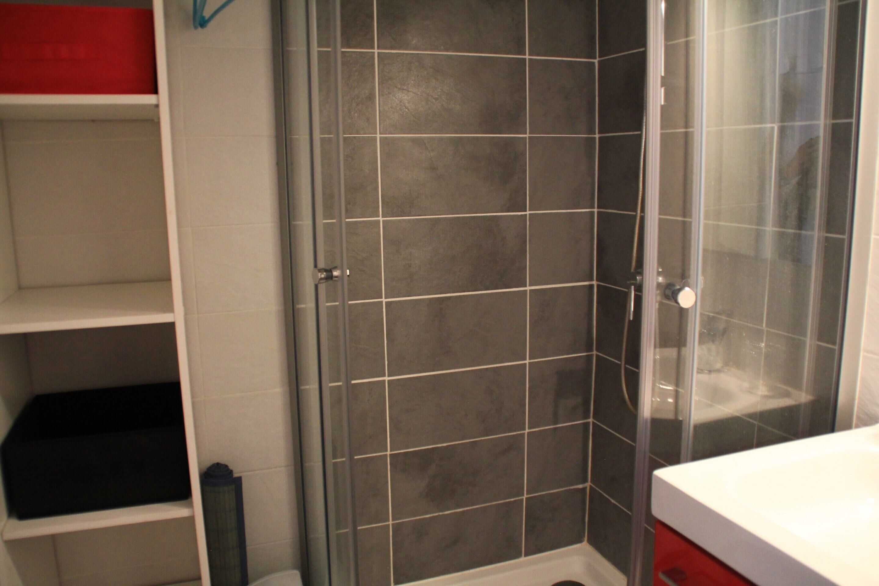 A bathroom with a shower, a toilet, and a sink.