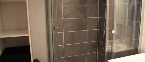 A bathroom with a shower, a toilet, and a sink.