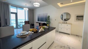 Een moderne keuken met een eethoek, grote ramen en uitzicht op zee.