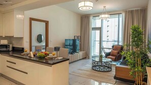 Een moderne woonkamer met een centraal eiland, een bank, een salontafel en een televisie.