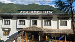A building labeled "Hotel Classic Wood" with a traditional architectural style, featuring multiple windows and a covered entrance area. - Hotel Classic Wood (Punakha)