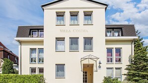 En toetages bygning kaldet "Villa Cosima" med en symmetrisk facade, flere vinduer og en central indgang.