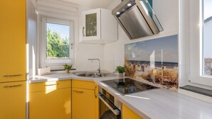 A modern kitchen with yellow cabinets, a stainless steel sink, and a built-in oven.