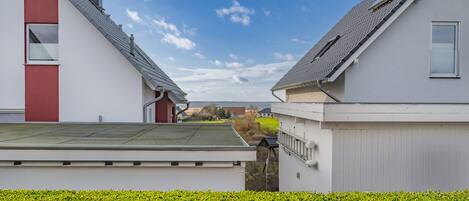 A residential area with modern houses, a clear sky, and well-maintained greenery.