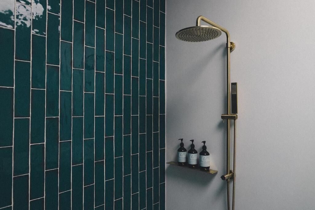 Une salle de bain moderne avec une douche et un mur recouvert de carreaux.