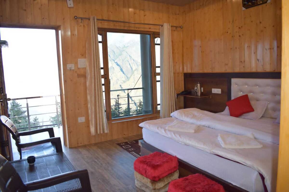 Una habitación de cabaña de madera con cama, mesa y silla.