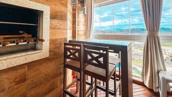 Una cocina con estufa integrada, armarios de madera y ventana con vista a la ciudad.
