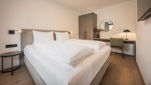 Une chambre d’hôtel moderne, dotée d’un grand lit, d’un bureau et d’une chaise.