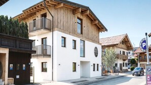 Un bâtiment à deux étages doté d’une façade en bois et d’un balcon.
