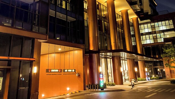 A modern building with large glass windows and a prominent entrance with a vertical light feature. - The Galleria Residence by Hava  (Ho Chi Minh City)