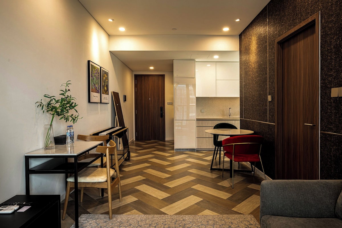 A compact living space with a dining area, kitchenette, and a sofa.