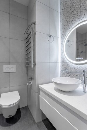 A modern bathroom with a white sink, a toilet, and a shower area. - Boulevard 114 (Tashkent)