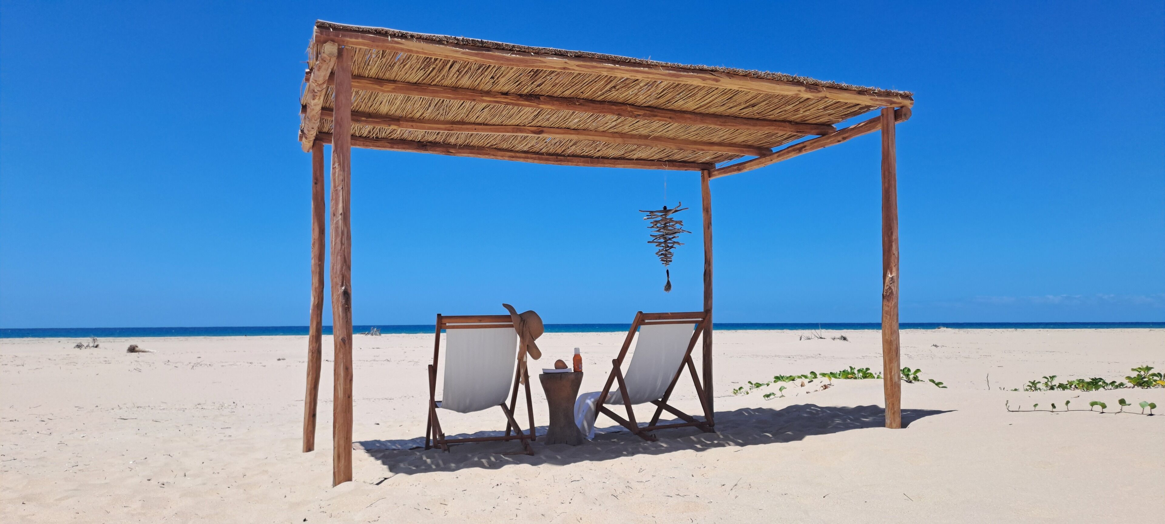 En la playa, sillas reclinables de playa, sombrillas, toallas de playa