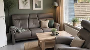 A modern living room with a sofa, a coffee table, and a lamp.