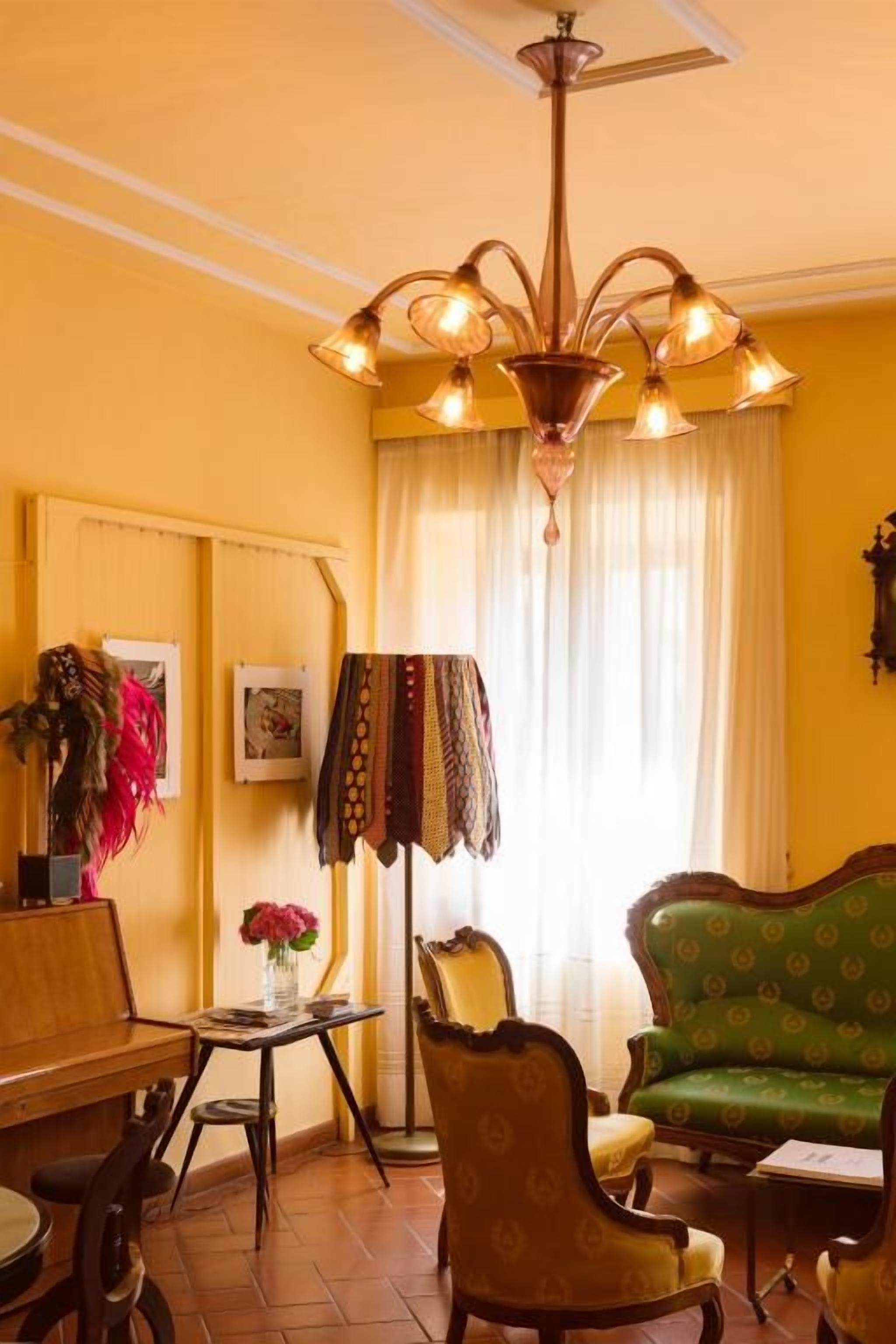 Una habitación con candelabro, sofá, mesa y silla.