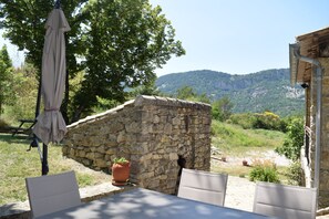 Ein Sitzbereich aus Stein mit Blick auf eine gebirgige Landschaft.