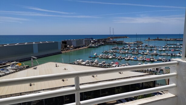 A marina with numerous boats docked, a clear blue sky, and a view of the sea. - First Line Apartment With Wifi (Benicarlo)