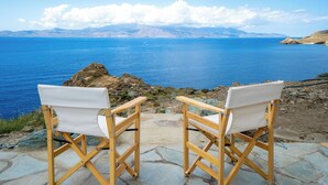 Two wooden director's chairs facing a scenic view of a calm sea and distant mountains. - Seahorse Villa Andros: Beachfront with Private Pool (Kalamitsi, Andros)