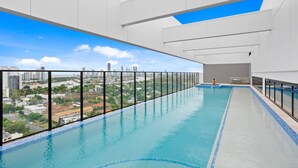 Ein modernes Hallenbad mit Blick auf die Stadt, umgeben von weißen Wänden und einem Wanddesign mit Muster.