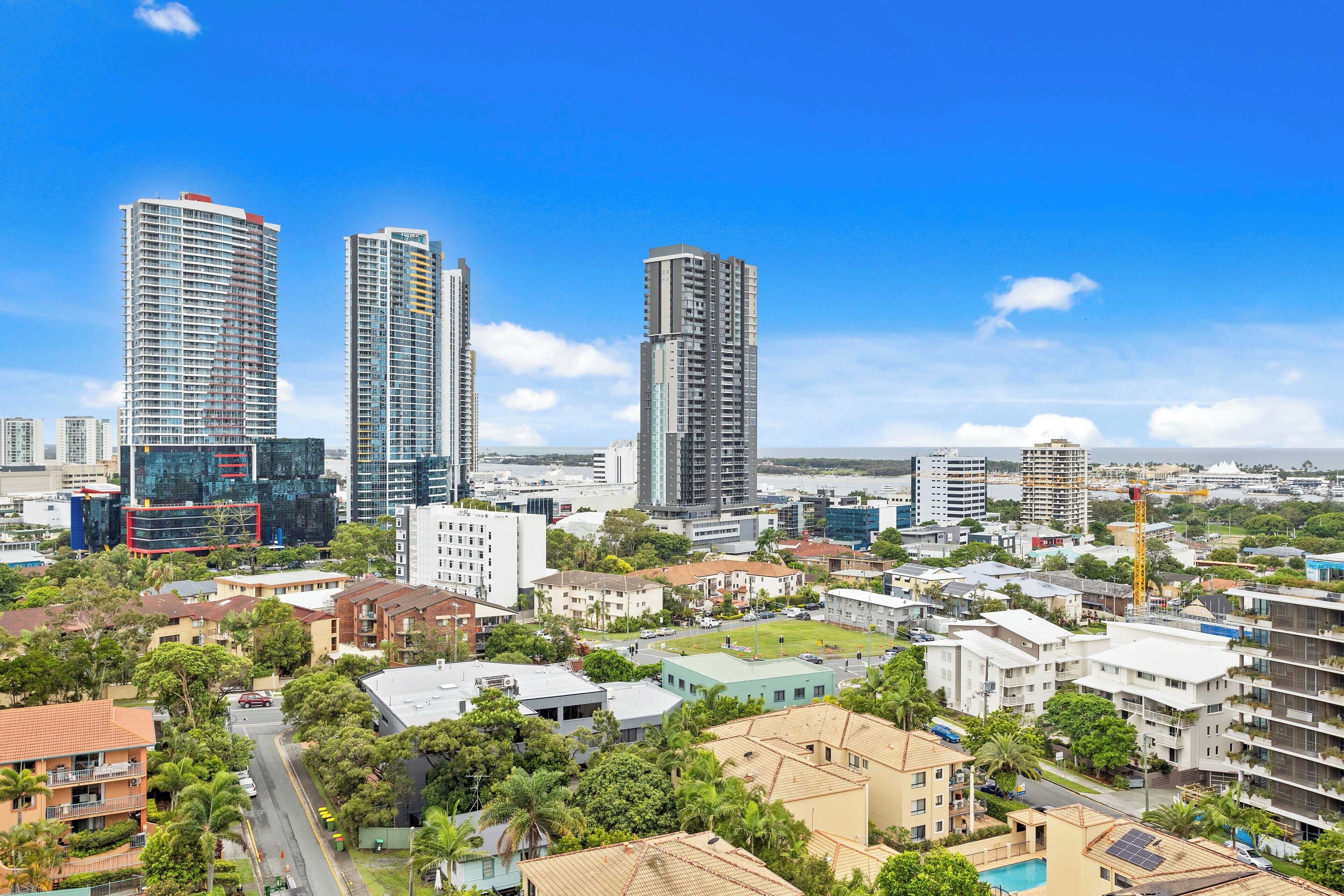 A cityscape with high-rise buildings, a mix of residential and commercial structures, and a clear blue sky.