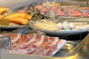 A buffet with various food items including meats, cheeses, and fruits. - Albergo all'Ancora (Garda)