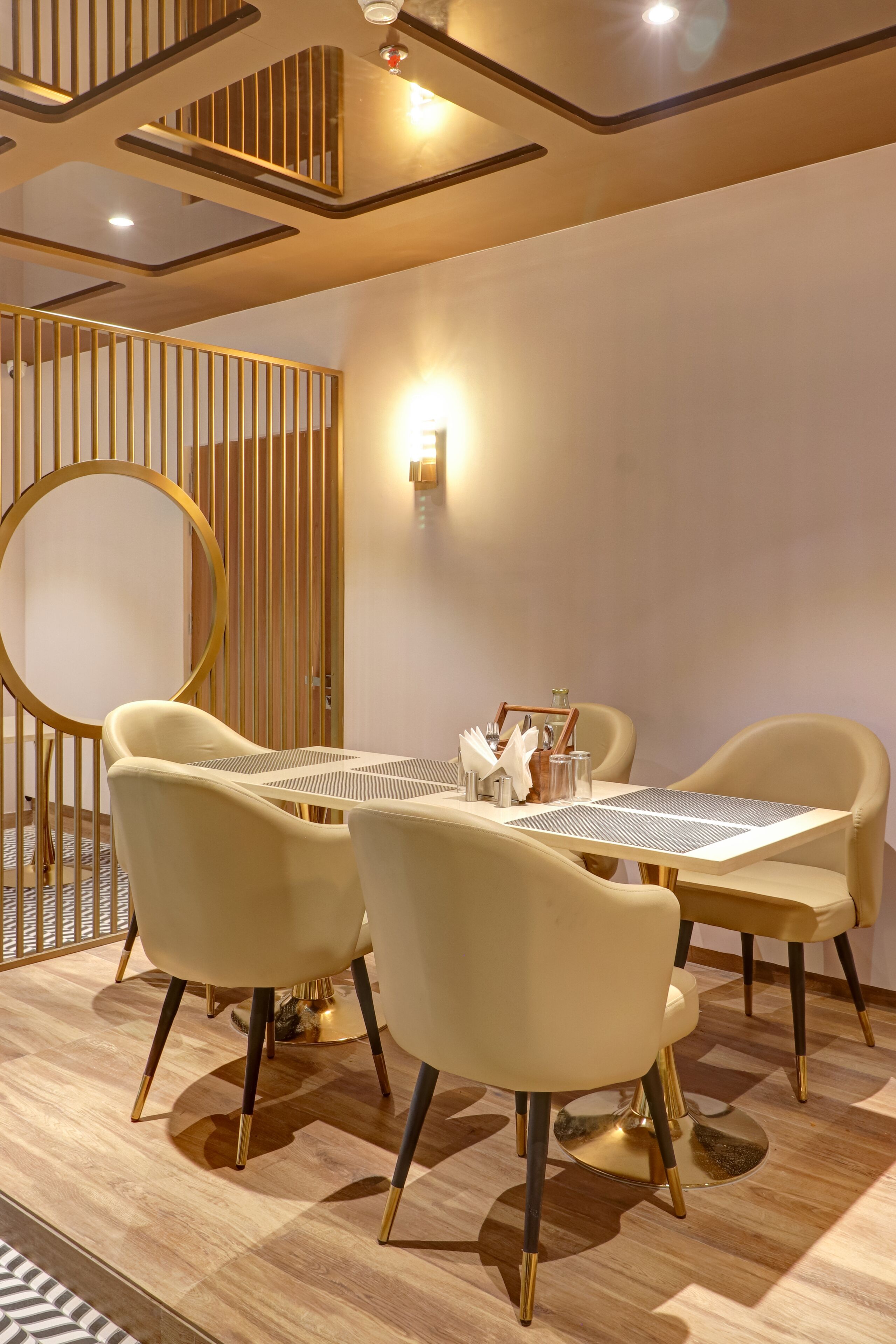 A modern dining area with a round table, four chairs, and a decorative wall panel.