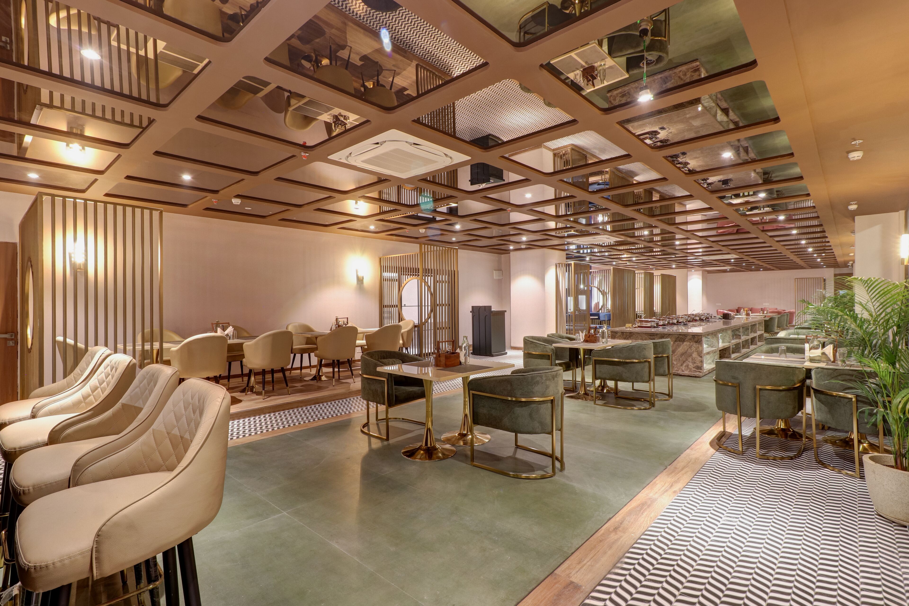 A spacious hotel lobby with multiple seating areas, a central bar, and a high ceiling with a geometric design.