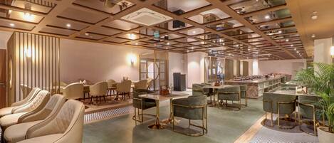 A spacious hotel lobby with multiple seating areas, a central bar, and a high ceiling with a geometric design.