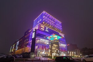 Un edificio de varios pisos con señalización iluminada y una entrada destacada.