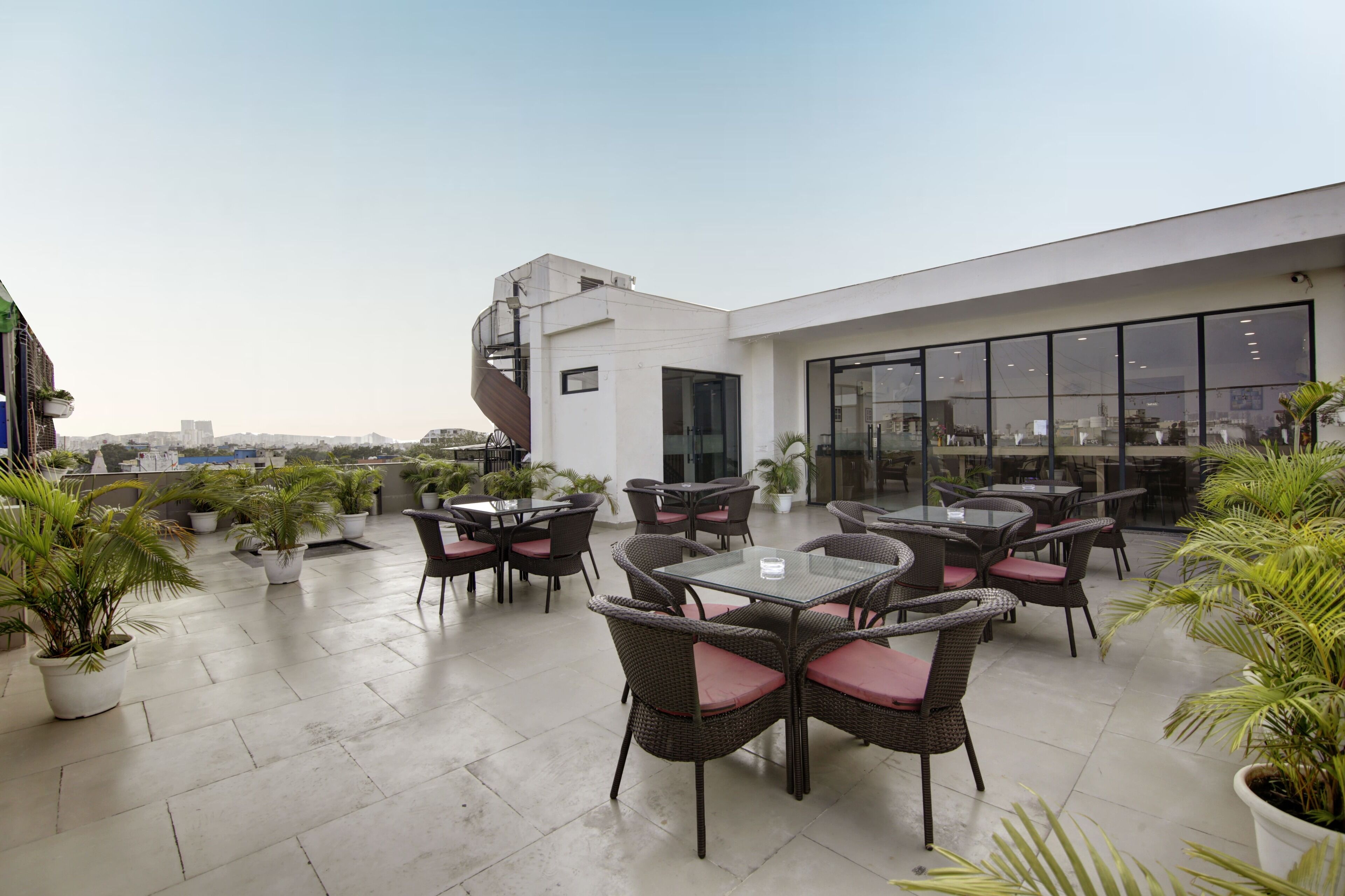 A rooftop terrace with outdoor seating and potted plants.