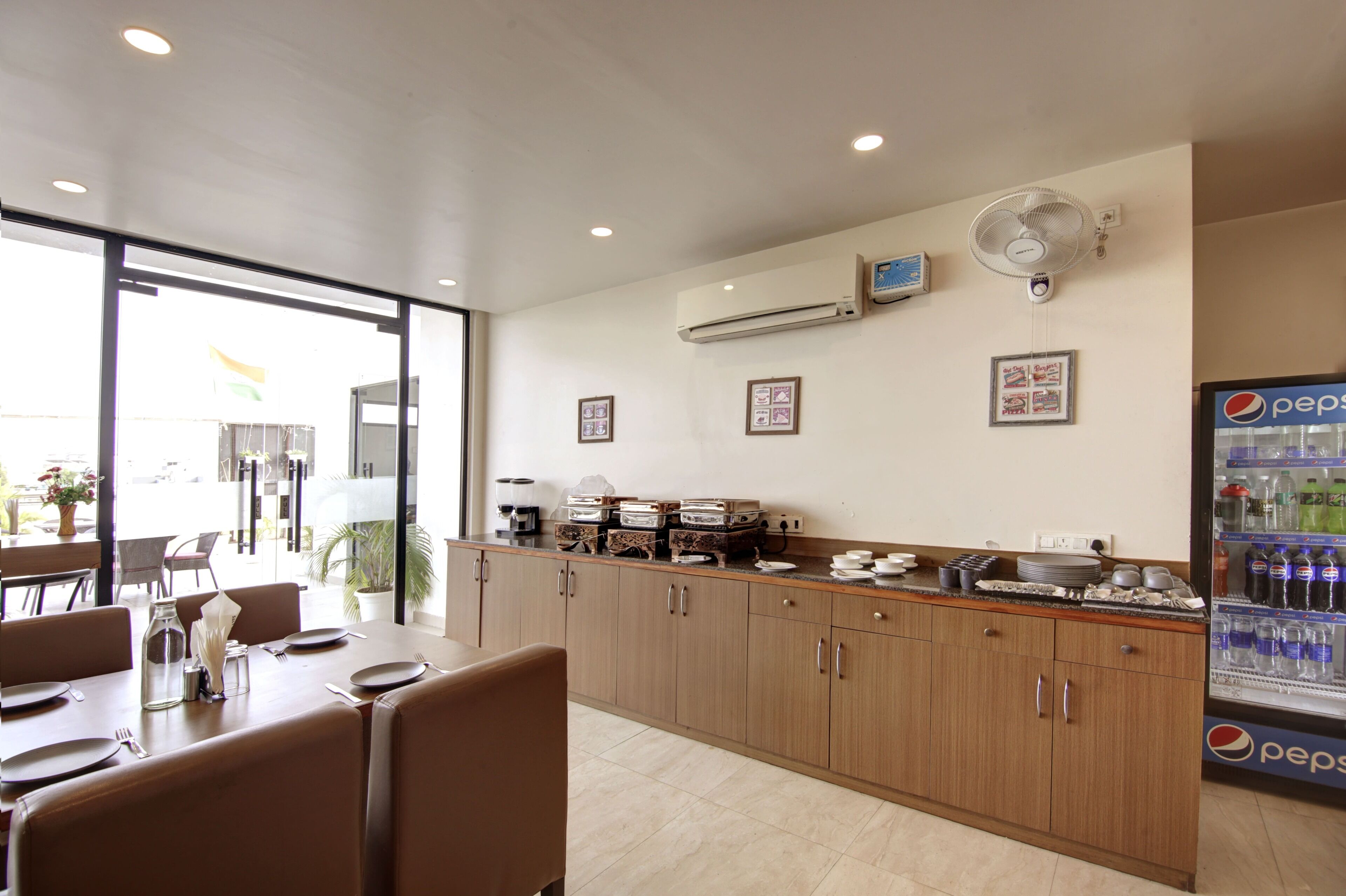 A modern kitchen with wooden cabinets, a built-in stove, and a refrigerator stocked with beverages.