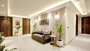 Un moderno vestíbulo de hotel con piso estampado, un sofá, plantas en macetas y obras de arte enmarcadas en las paredes.