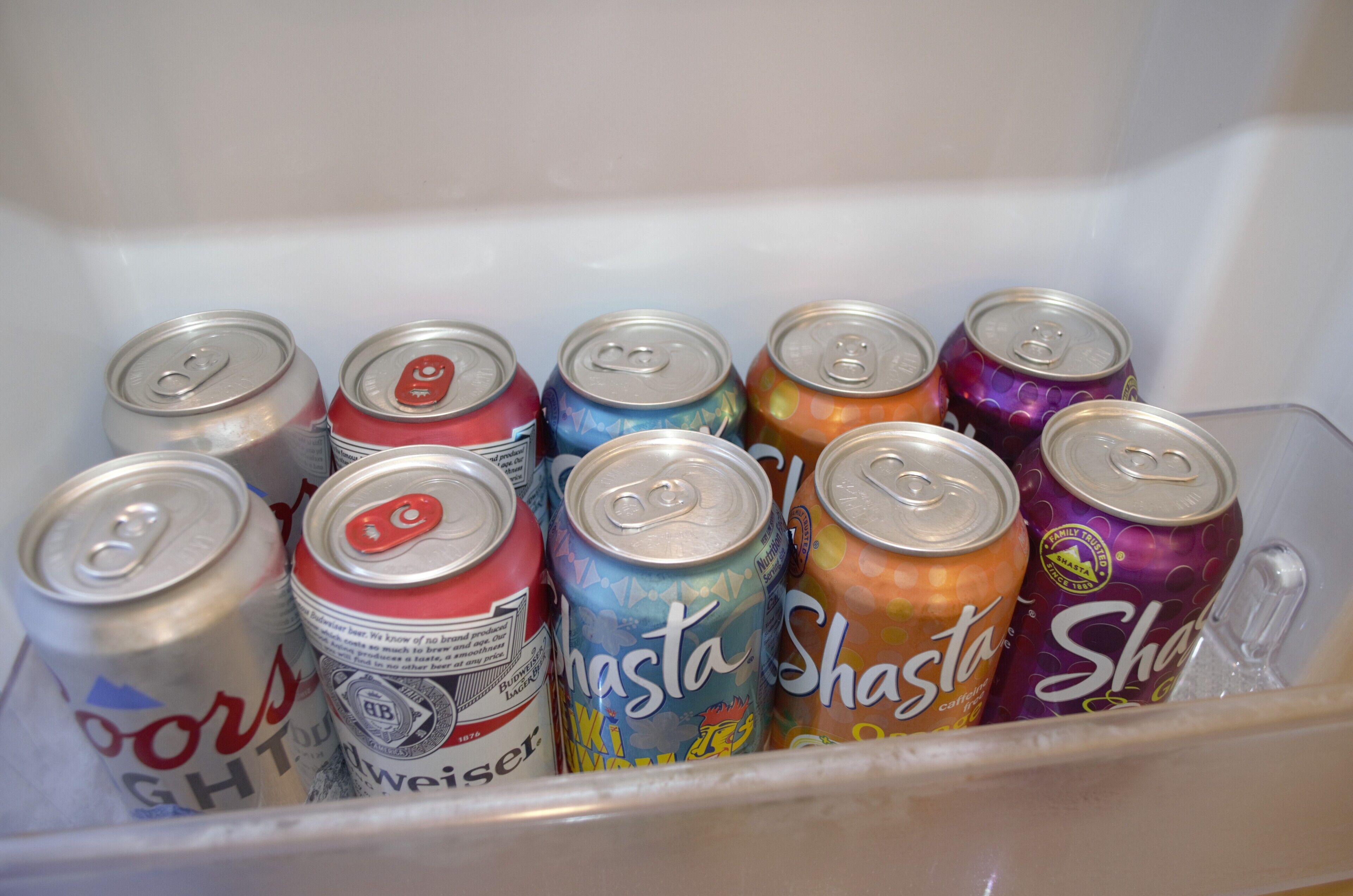 A freezer containing various cans of beverages.