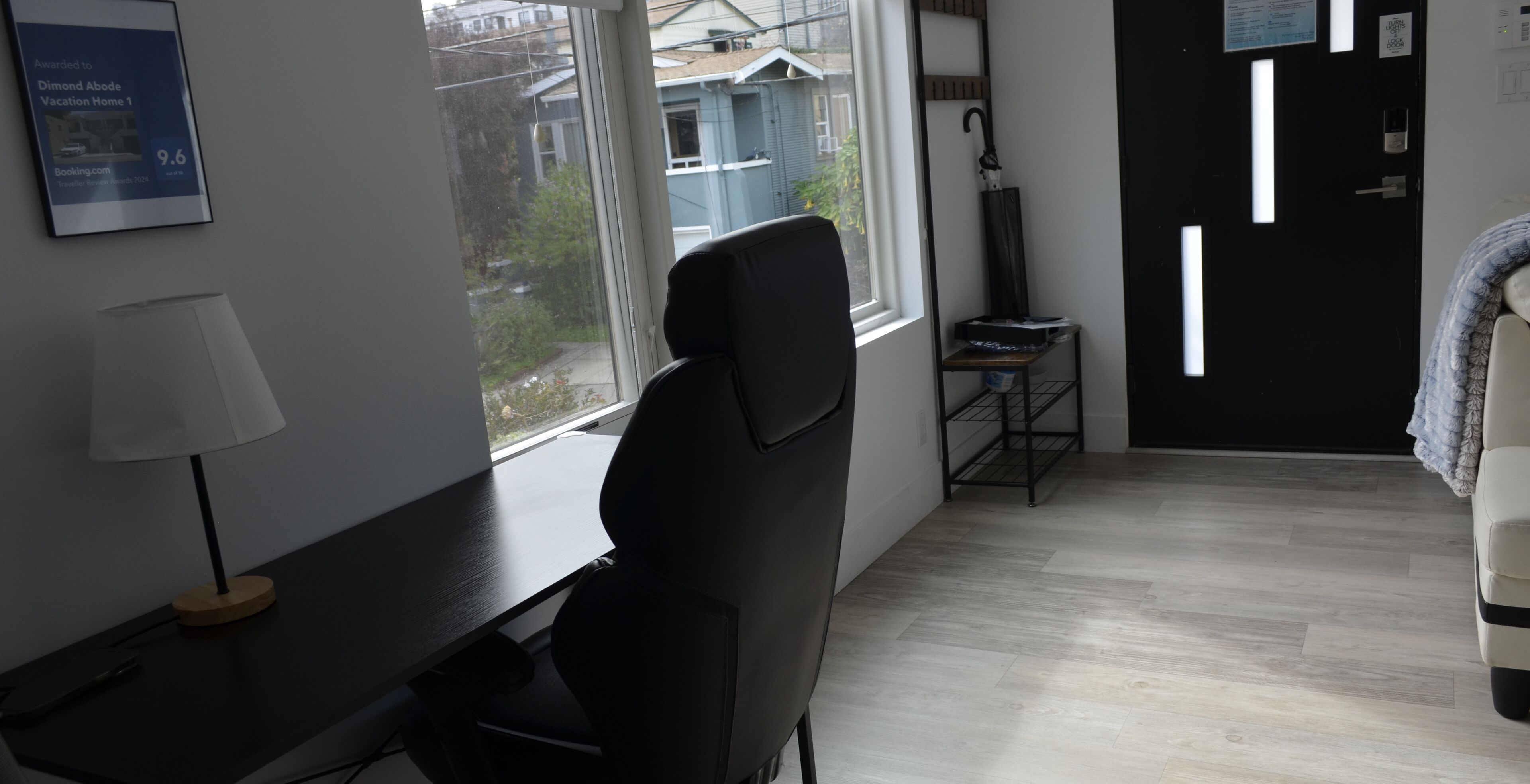 A modern hotel room with a desk, chair, and a view of the outside.