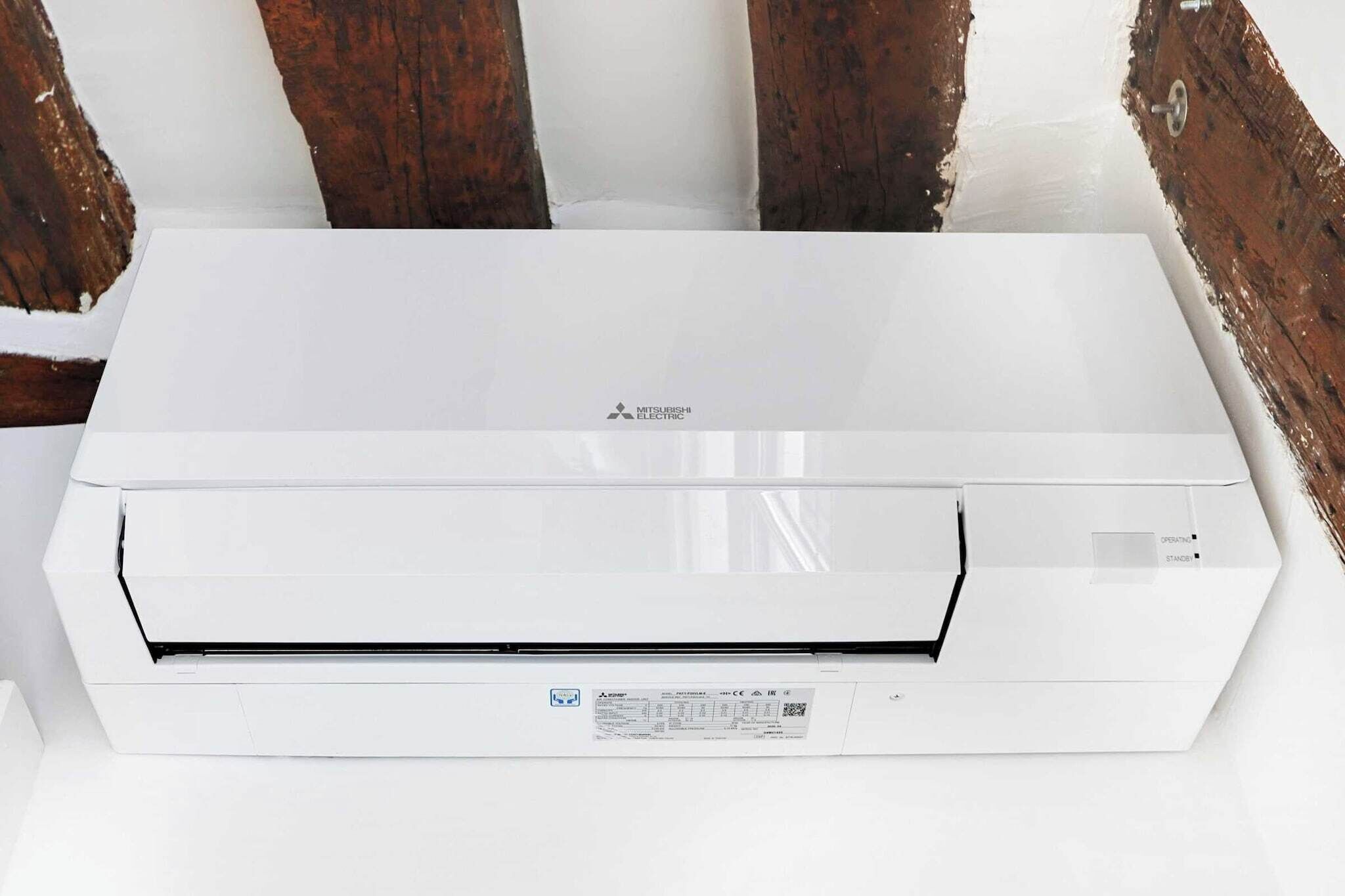 Un equipo de aire acondicionado blanco con panel de control y etiqueta.