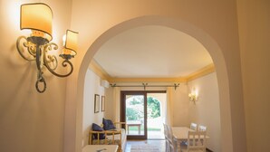 Un interno con zona pranzo, un divano e due lampade a parete.