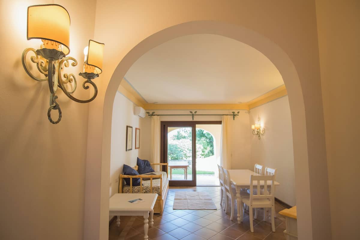 Un intérieur comprenant un coin repas, un canapé et deux lampes fixées au mur.