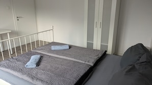 A bedroom with a bed, a wardrobe, and a small table. - NestOaseWHV Zimmer zw.City und Südstrand (Wilhelmshaven)