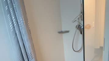 Regadera, piso con calefacción, toallas, papel de baño