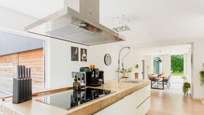A modern kitchen with a large island, built-in appliances, and a dining area with natural light. - Lanaken Retreat Pool Jacuzzi and Sauna (Lanaken)
